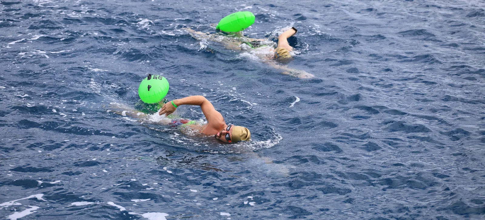 October 2026, Kemer: two swimmers with green buoys in open sea.