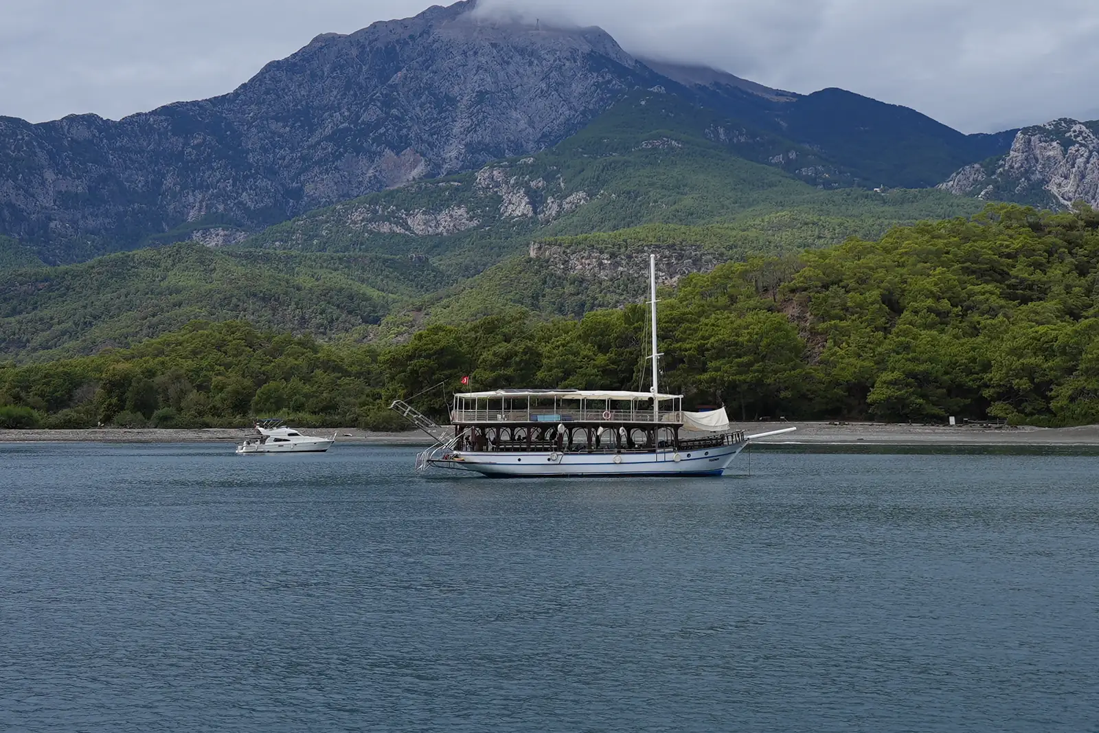 Ekim 2026, Kemer: Tahtalı Dağı'nın eteğinde sakin koy, kıyıya yakın demirli bir gulet.