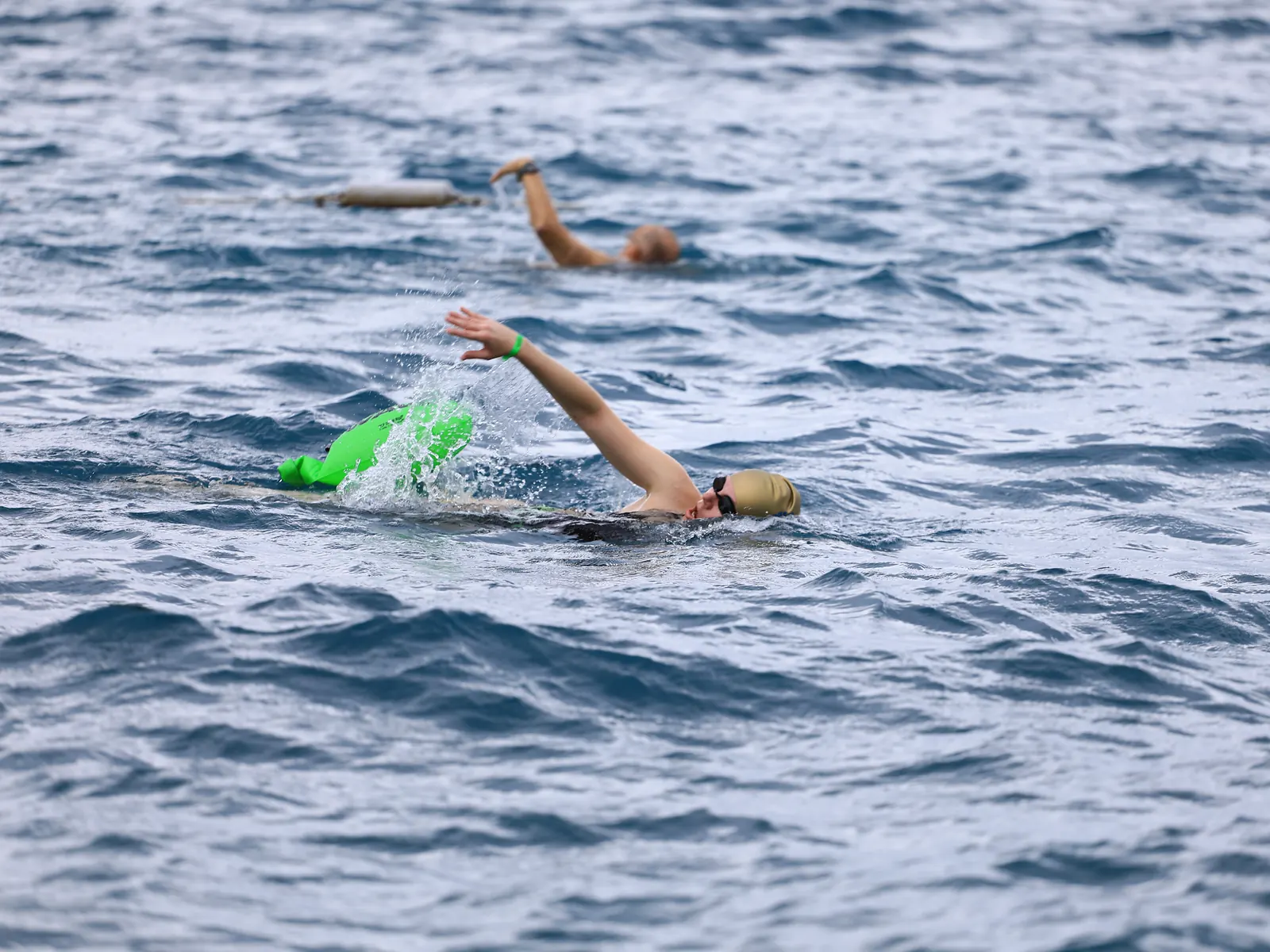 Ekim 2026, Kemer: yeşil tow float'ıyla sağa doğru serbest stil yüzen bir katılımcı, arkasında ikinci bir yüzücü.