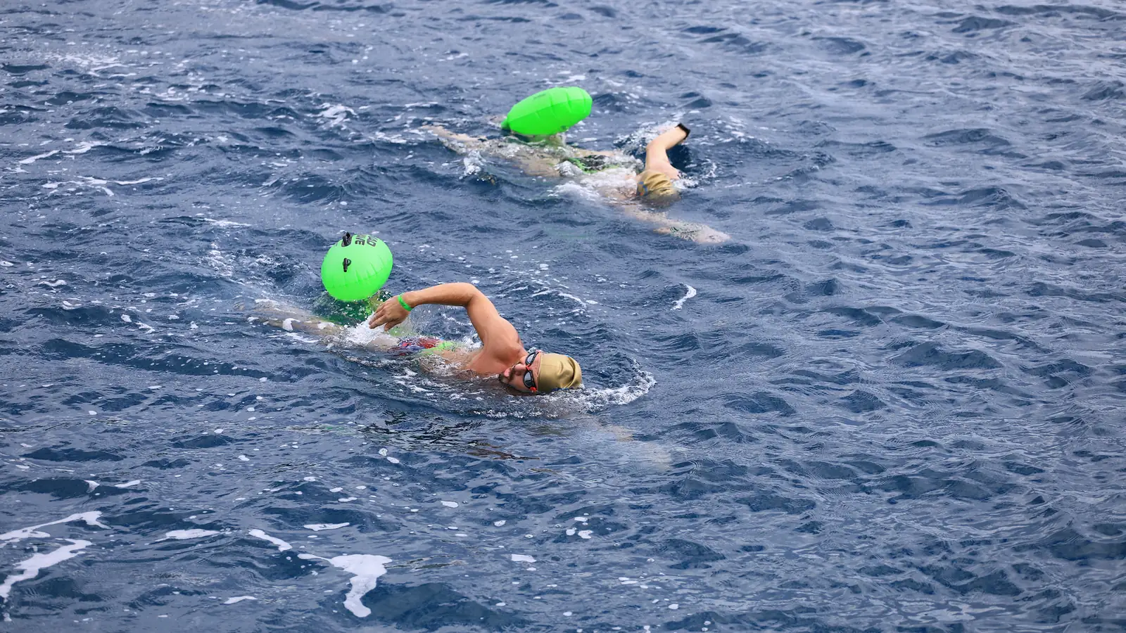 Ekim 2026, Kemer: yeşil tow float'larıyla yan yana yüzen iki katılımcı, mavi derin su.